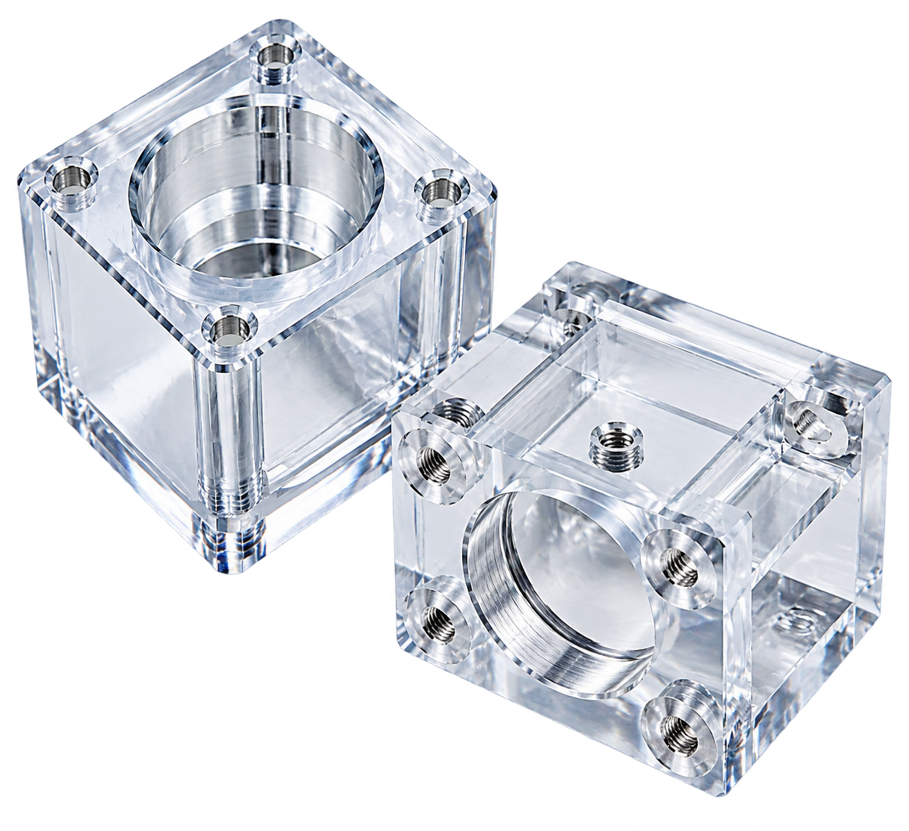 Two transparent CNC machined polycarbonate blocks with central bores and threaded inserts, polished clear